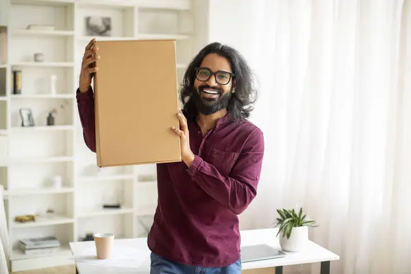 配達コンセプト 自宅で大きな配達箱を抱擁するエキサイティングな若いインド人男性 注文されたアイテムと小包を保持する陽気なミレニアル東部男性 速い配送に感情的に反応する コピースペース — ストック写真