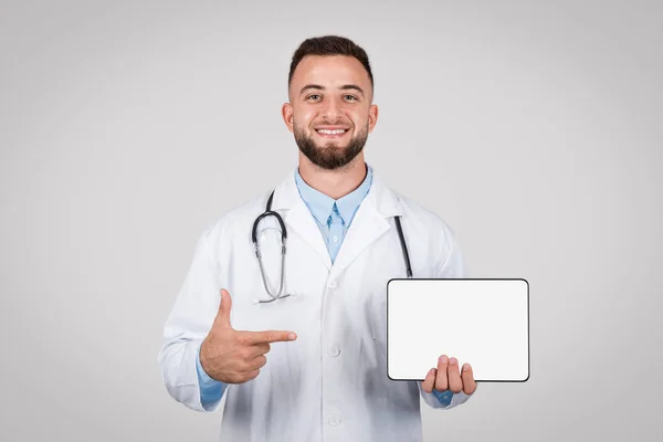 Carismático Joven Médico Con Estetoscopio Apuntando Pantalla Tableta Blanco Perfecto —  Fotos de Stock