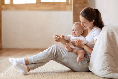 Anne, hasta bebek ve tıbbi risk için termometre, değerlendirme sonuçları ve evde grip enfeksiyonu. Anne, ağlayan bebek, çocuk ve ateşini kontrol ediyor.