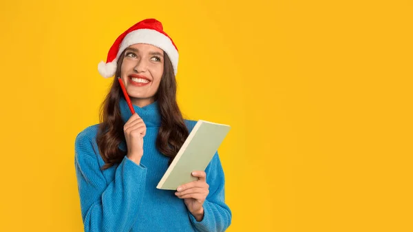 Europäerin Lächelt Träumend Und Schreibt Weihnachtsfestträume Und Verkaufswünsche Ihr Notizbuch — Stockfoto