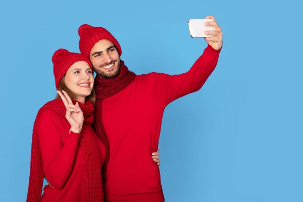 Joven Pareja Alegre Usando Sombreros Invierno Divirtiéndose Mientras Toma Selfie — Foto de Stock