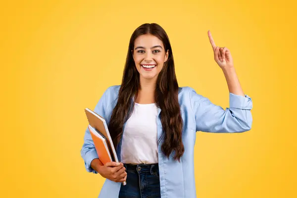 快乐聪明的欧洲裔女学生 带着书本学习 指指点点复制空间 孤立在黄色的工作室背景下 学校推荐 广告和提供的学生生活方式 — 图库照片