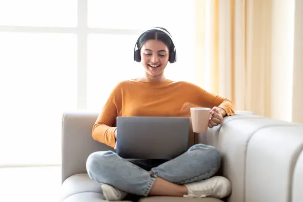Young Indian Woman Wearing Wireless Headphones Resting Laptop Coffee Couch — Stock Photo, Image