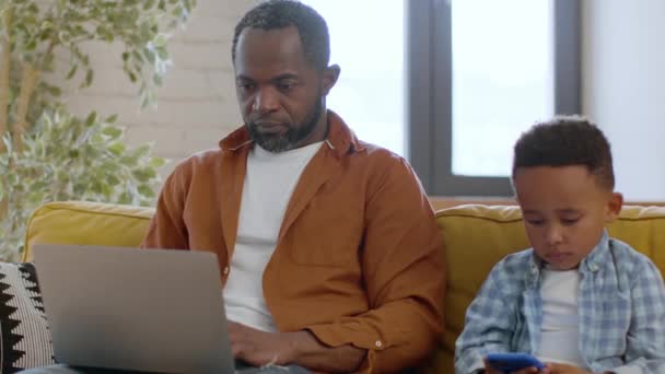 Ligação Digital Jovem Afro Americano Ocupado Trabalhando Laptop Casa Olhando — Vídeo de Stock