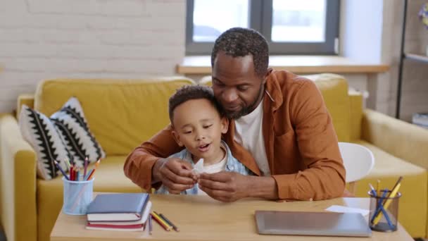 自宅でのクリエイティビティ開発 愛するアフリカ系アメリカ人の父親は折り紙を作るために彼の息子を教え ペーパーバタフライを作り 自宅でそれを楽しむ興奮した少年 — ストック動画