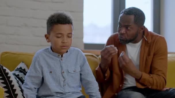 严厉的爱情概念 情绪激动的非洲裔美国父亲在家里训斥他的小儿子 不幸的男孩坐在一边 跟踪镜头 慢动作 — 图库视频影像