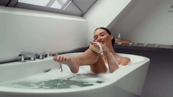 Záběry Šťastná Žena Vaně Bohaté Bublinky Pomocí Exfoliační Kartáč Ruce — Stock video