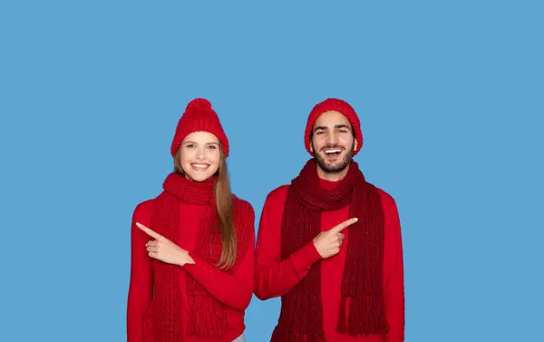 Fröhliches Junges Paar Wintermützen Die Mit Fingern Nach Links Und — Stockfoto