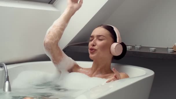 슬로우 영상은 목욕에서 행복한 여자를 헤드폰을 음악에서 손실과 소리로 장면은 — 비디오