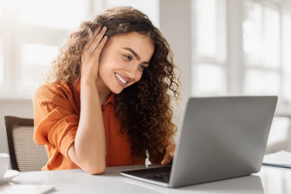 Vrolijke Krullende Vrouw Oranje Shirt Werkend Laptop Leunend Hand Met — Stockfoto
