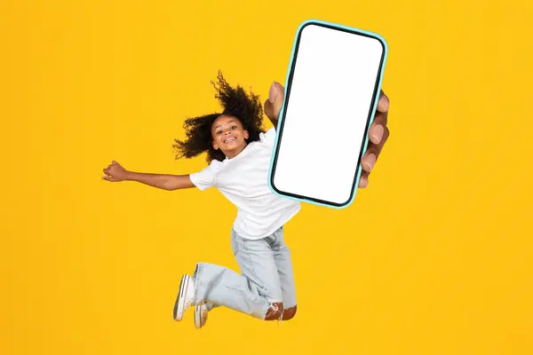 Adolescente Afroamericana Mostrando Enorme Smartphone Con Pantalla Blanco Saltando Aire — Foto de Stock