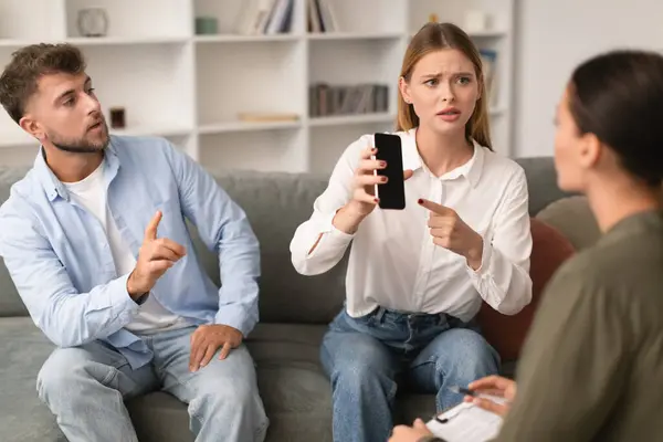 Jealous Young Wife Shows Smartphone Empty Screen Consultation Psychologist Office — Stock Photo, Image