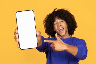 Çevrimiçi reklam. Sarı Stüdyo 'nun arka planında izole edilmiş, boş akıllı telefonu işaret eden neşeli siyahi adam, Yeni Uygulama ya da Web sitesi öneren mutlu Afrikalı Amerikalı adam,