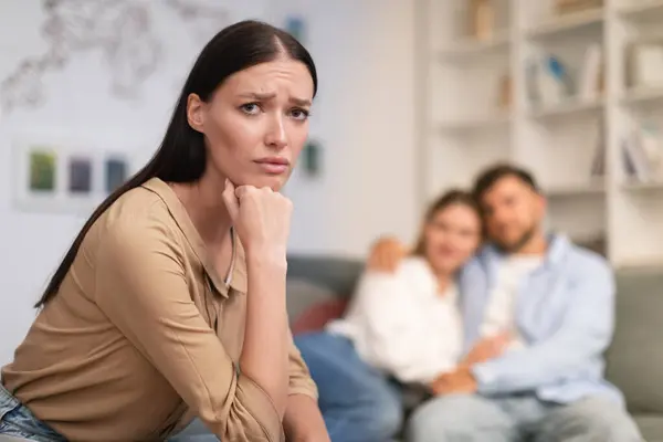 Millennial Couple Embraces Couch While Unhappy Young Lady Looking Camera — Stock Photo, Image