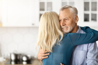 Sevgili eşinin evde yaşlı kocasını kucaklaması, kıdemli romantik eşlerin mutfak içinde kucaklaşması, yaşlı adamla kadının birbirine bağlanması ve birlikte vakit geçirmekten hoşlanması,