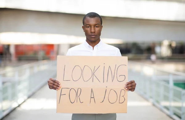 仕事のテキストプラカードを探し 不幸なアフリカ系アメリカ人の男性が仕事を失い 失業危機に苦しみ アウトドア コピースペース — ストック写真