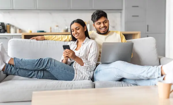 Mutlu Genç Hintli Çift Evdeki Koltukta Modern Gadget Larla Rahatlarken — Stok fotoğraf