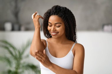 Vücut Bakımı Konsepti. Gülümseyen Siyah Kadın Nemlendirici Krem Sürerken Evde Banyo Yaparken, Çekici Afro-Amerikan Kadın Besleyici Losyon Uyduruyor, Kopyala Boşluk