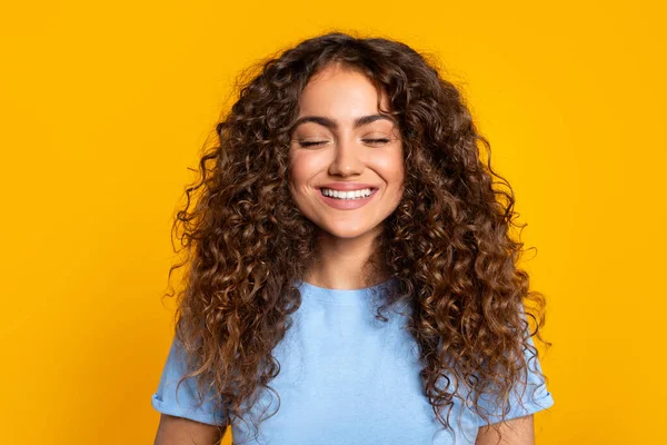 Zadowolona Młoda Kobieta Zamkniętymi Oczami Promiennym Uśmiechem Pokazująca Kręcone Włosy — Zdjęcie stockowe