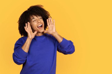 Eli Ağzı Yakın Genç Zenci Heyecanlı Afro-Amerikan Erkek Erkek Haberleri ya da Bilgileri Sarı Stüdyo Arkaplanda Tek Başına Dururken Duyuruyor, Boşluğu Kopyala