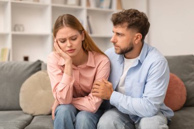 Koca, depresyondaki karısını rahatlatıyor ve destekliyor. Evdeki koltukta oturuyor. Evlilikle ilgili sorunları olan ve mücadele eden bir çift. Kadın Depresyonu ve Aile Krizi Konsepti