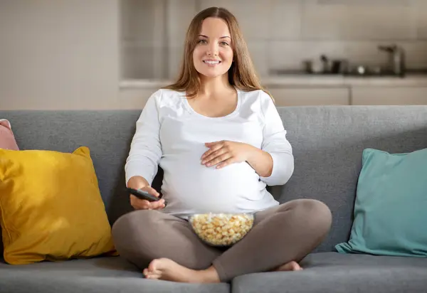 Szczęśliwa Kobieta Ciąży Relaks Kanapie Domu Oglądanie Telewizji Jedzenia Popcorn — Zdjęcie stockowe