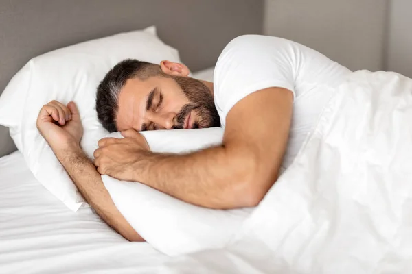 Homem Dormindo Confortavelmente Cama Envolto Cobertor Abraçando Travesseiro Branco Sono — Fotografia de Stock