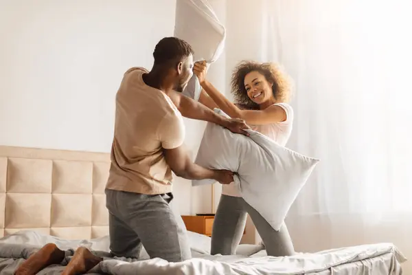 Unbekümmerte Junge Schwarze Ehepartner Kämpfen Mit Kissen Haben Spaß Und — Stockfoto
