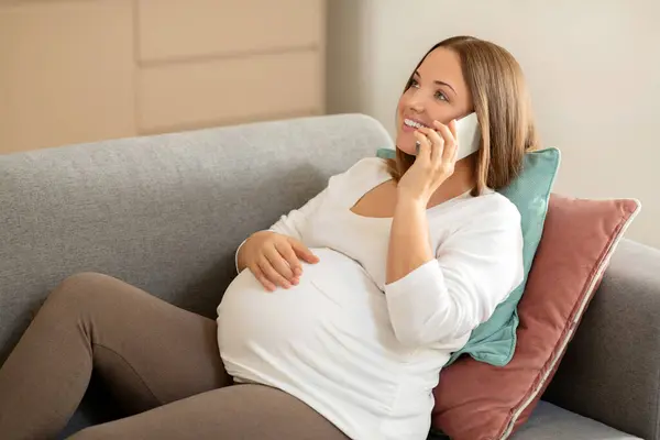 Güzel Hamile Bir Kadın Cep Telefonuyla Konuşuyor Koltukta Otururken Karnını — Stok fotoğraf