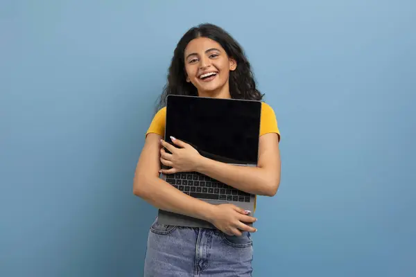 喜んで幸せな若いインドの女性学生は 空白の画面でノートパソコンを抱き 新しいガジェットコンピュータを購入し 青い背景に隔離されました 最新技術デバイス — ストック写真