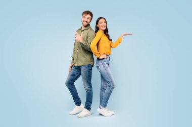 Sırt sırta duran mutlu erkek ve kadın, açık mavi arka planda farklı yönleri işaret ederek, seçim ya da çeşitlilik öneriyor