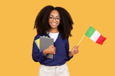 Smiling black lady student with Italian flag, enjoy exchange study, courses, isolated on yellow background. Lifestyle, national pride and learning Italian language