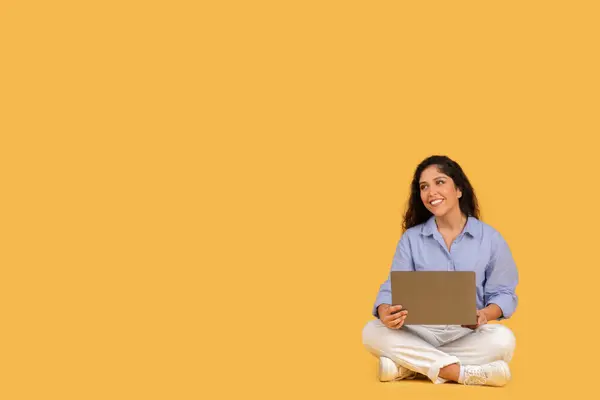 Content Young Adult Woman Sitting Cross Legged Yellow Background Looking — ストック写真