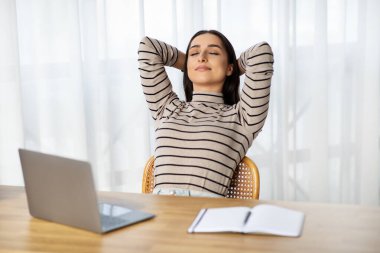 Smiling young caucasian lady manager work at laptop, rest, take break from work in living room interior. Business, freelance and free time relax, lifestyle at home office