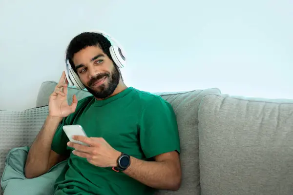 Relaxed Arab Young Man Beard Green Shirt Lounging Gray Couch — стоковое фото