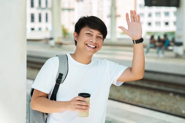Positive Young Asian Guy Tourist Waving Smiling Camera Holding Takeaway — Stockfoto