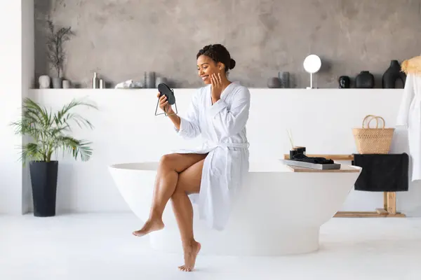 Attractive Young Black Woman White Bathrobe Sitting Edge Bathtub Looking — Foto de Stock