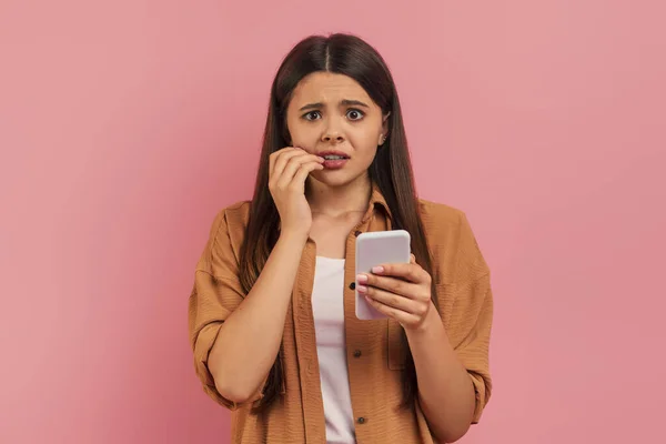 Anxious Teenage Girl Biting Her Nails While Looking Smartphone Concerned — 스톡 사진
