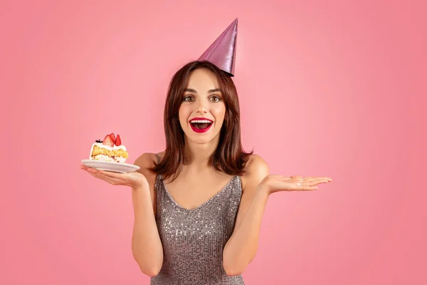Excited Woman Glittery Dress Party Hat Presenting Delicious Piece Cake — Stok Foto