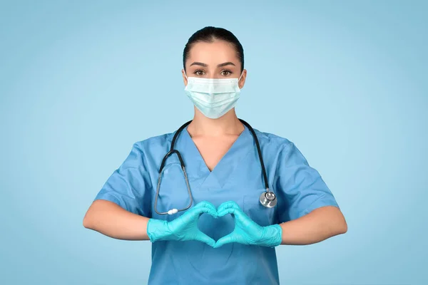 Compassionate Female Nurse Blue Scrubs Making Heart Shape Hands Wearing — Stock fotografie