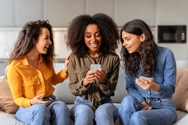 Three Multiethnic Women Friends Websurfing Cell Phones While Sitting Couch — Fotografia de Stock