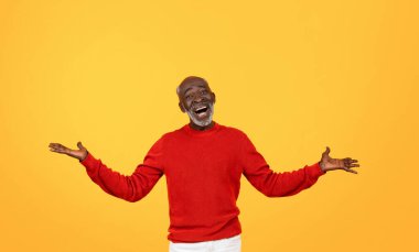 Joyful senior Black man with a white beard laughing and spreading his arms wide open, wearing a red sweater on a yellow background, exuding happiness and a welcoming vibe