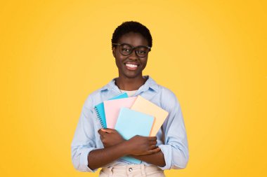 A black woman student, surrounded by books, displays a look of dedication and intellect, her focused gaze and studious posture against yellow background illustrating the essence of academic pursuit