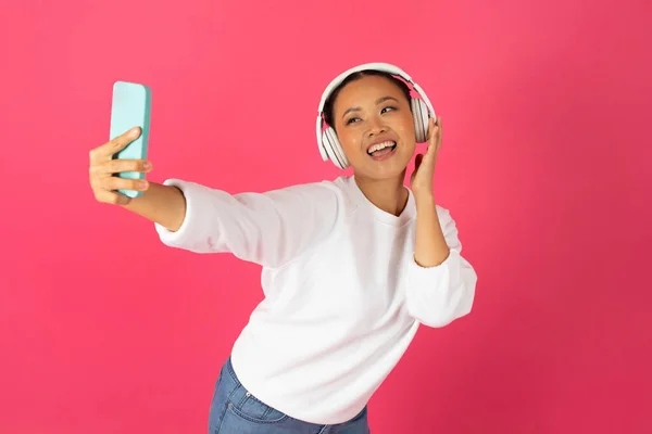 Neşeli Asyalı Kadın Kablosuz Kulaklık Takıyor Akıllı Telefondan Selfie Çekiyor — Stok fotoğraf