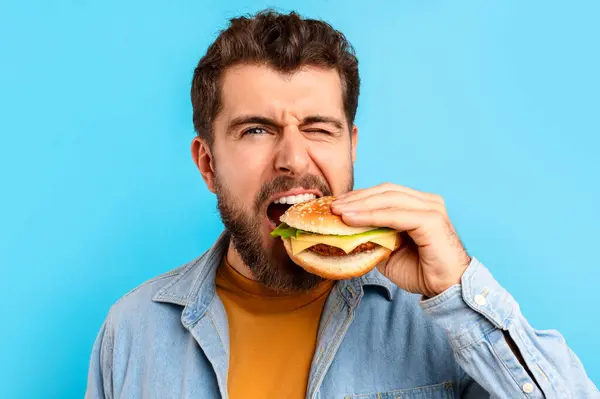 Portrait Young Bearded Man Biting Big Tasty Burger Isolated Blue — Stock Photo, Image