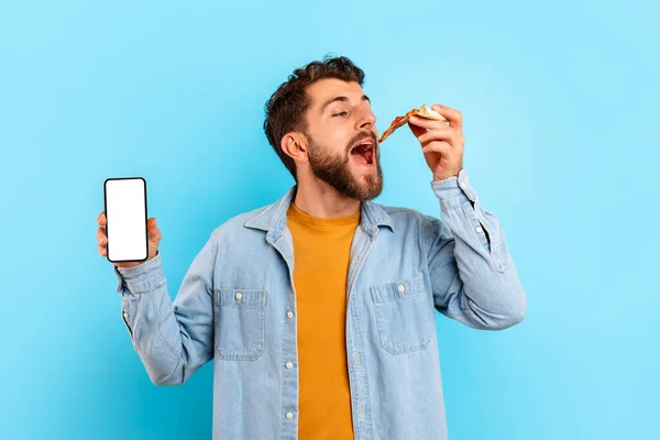 Man Eet Pizza Toont Mobiele Telefoon Met Leeg Scherm Blauwe — Stockfoto