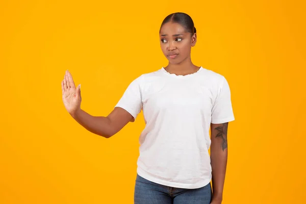 白いTシャツのオファーされたミレニアル黒人女性は 黄色いスタジオの背景に手でジェスチャーを停止し 悪いオファーを拒否し 不承認を表明します ハラスメント セクシズムで戦う — ストック写真