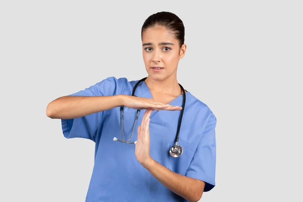 Zaniepokojona Europejska Pielęgniarka Niebieskim Fartuchu Robiąca Ręcznie Znak Czasowy Wskazujący — Zdjęcie stockowe