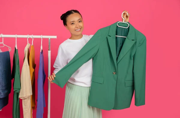 Веселая Азиатская Женщина Демонстрирует Новую Одежду Стоя Рядом Вешалкой Моды — стоковое фото