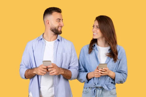 Mutlu Erkek Kadın Akıllı Telefonları Tutarken Birbirlerine Bakarlar Muhtemelen Dijital — Stok fotoğraf